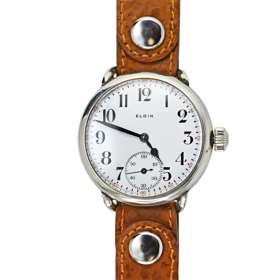 Front view of Elgin campaign style wristwatch showing white enamel dial, nickel case, and studded brown strap