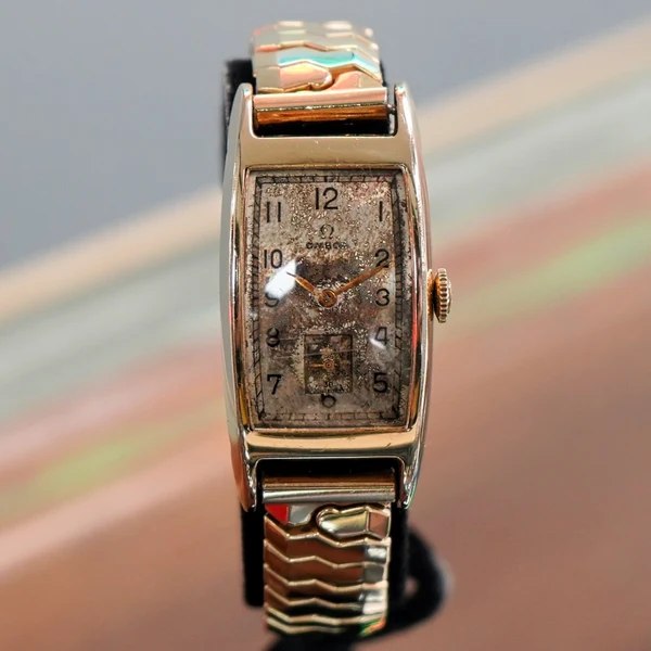 Front view of the 1945 Omega Cal. R17.8 tank case wristwatch on an expansion bracelet