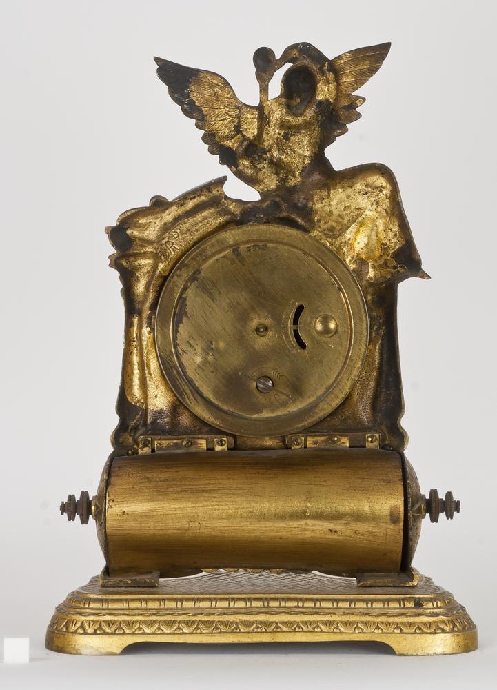 Rear view of the British United Clock Company gilt brass desk timepiece showing the case back and calendar cylinder