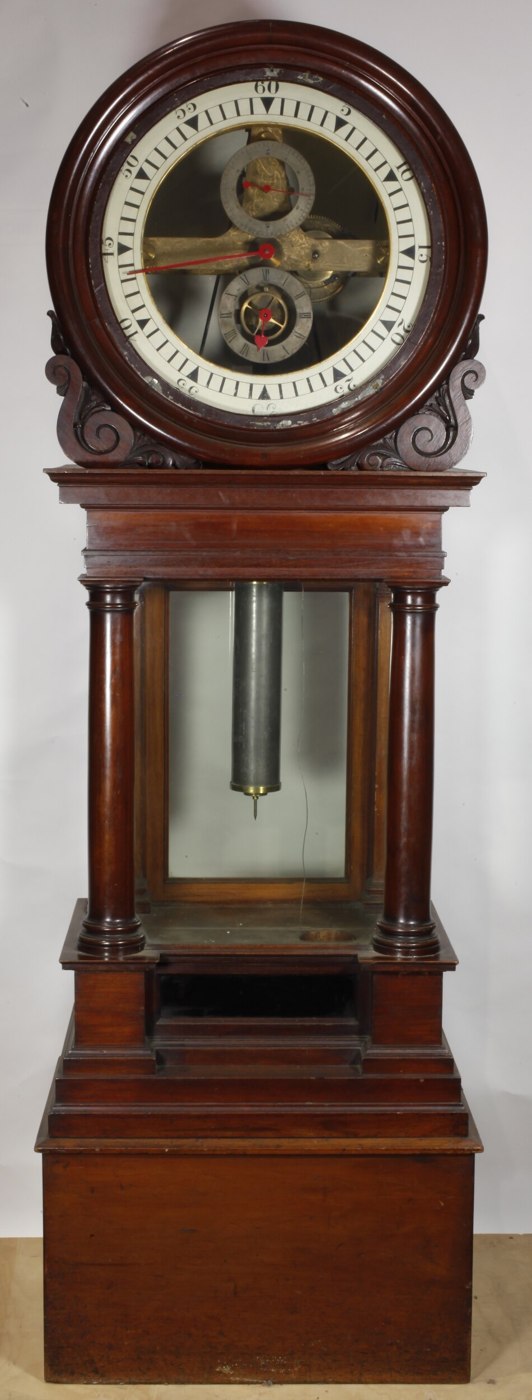 Full-length view of the longcase regulator clock showing the cylindrical dial housing, glazed trunk, and internal pendulum.