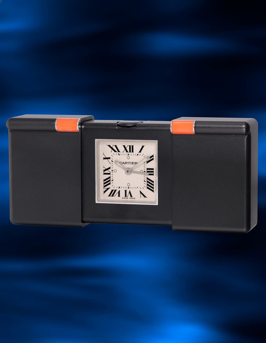 Front view of the Cartier Ermeto-style travel clock opened to show the dial and coral accents