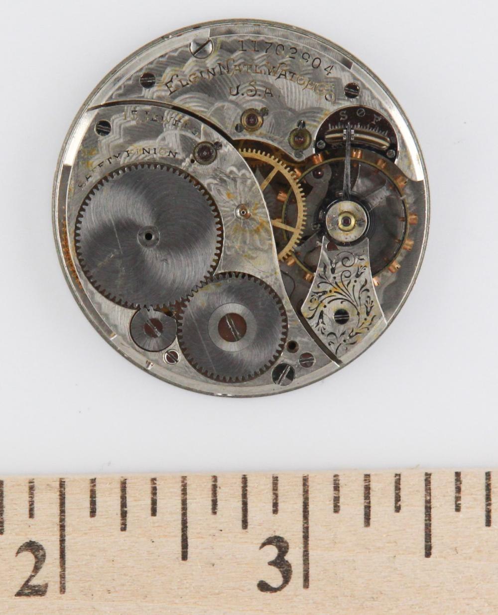 Movement plate view showing the serial number 11762904 and mechanical details, with a ruler for scale.