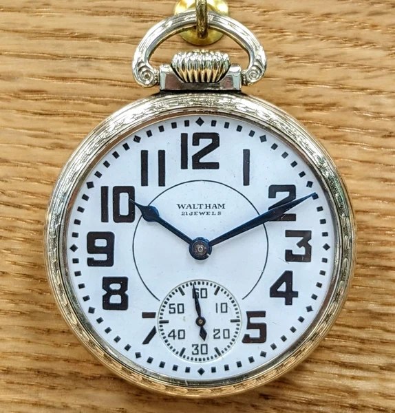 Front view of the open-face Waltham 21 Jewels pocket watch displaying white dial, blued hands, and sub-seconds dial