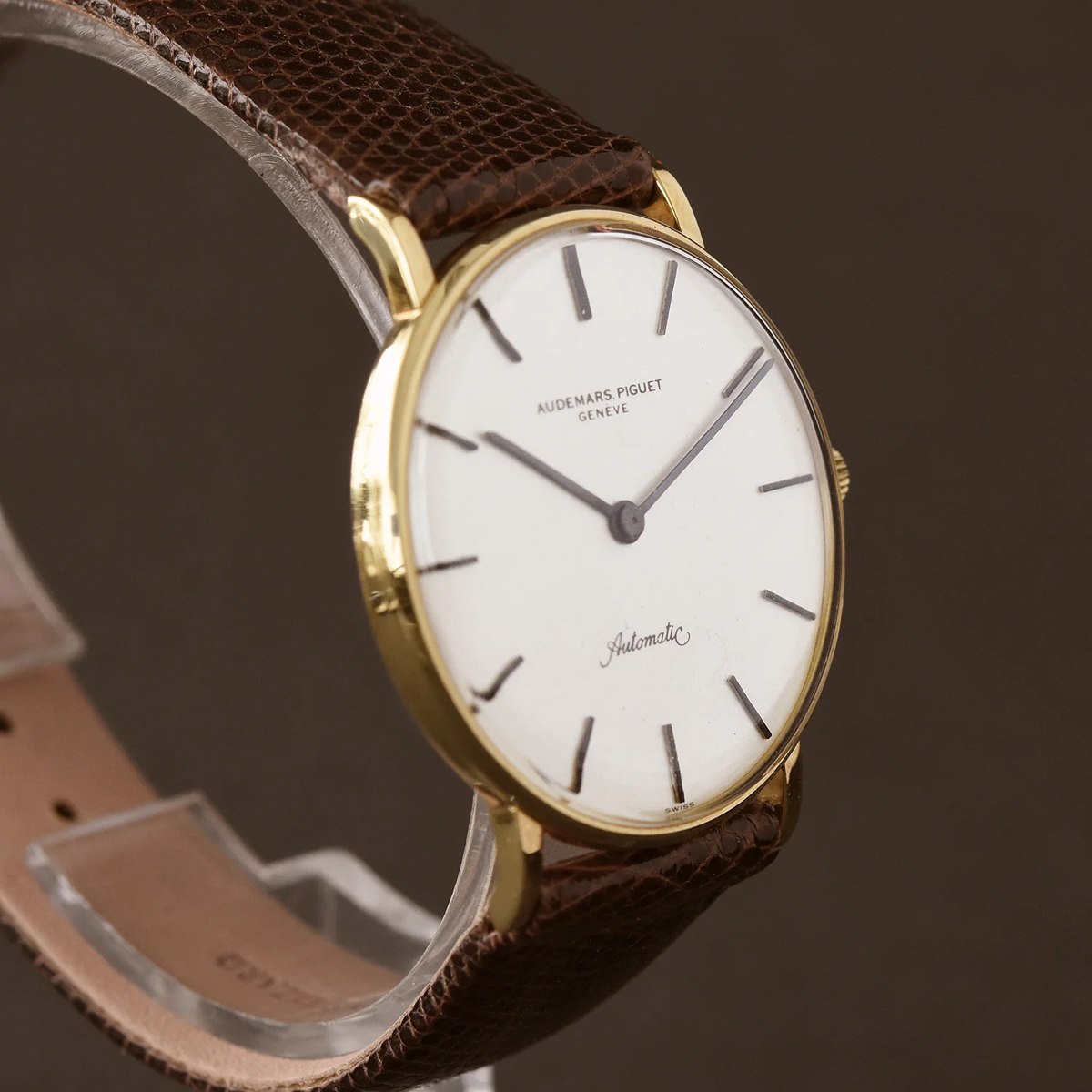 Oblique view of the Audemars Piguet K2120 18K yellow gold dress watch on a stand