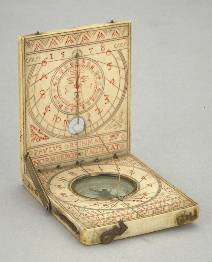 The diptych dial opened to show the sun-motif plumb bob and horizontal compass dial.