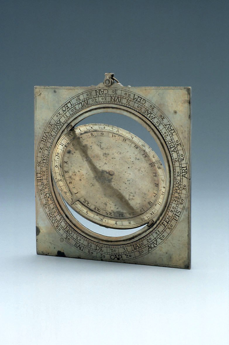 Front view of the brass ring dial, showing the central rotating disc and engraved zodiac scale on the square plate.